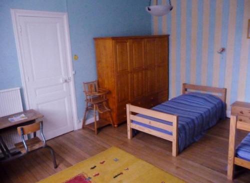 1 dormitorio con 1 cama, armario y mesa en L'esperance, en Haybes
