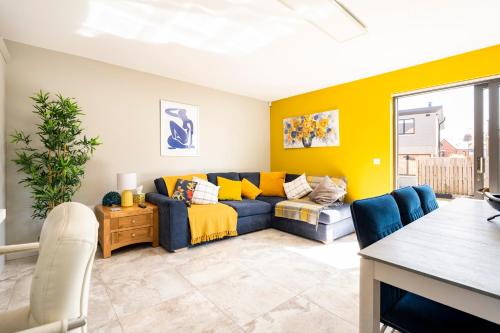 a living room with a blue couch and yellow walls at Park House - FOUR star luxury with parking and WI-FI in Belfast