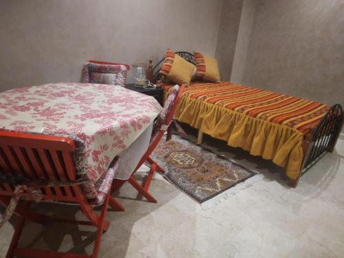 Cette chambre comprend une table, un lit et une chaise. dans l'établissement Golden Beach, à Dar Hamida
