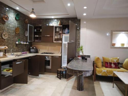 - une cuisine avec un comptoir et une table dans une pièce dans l'établissement Golden Beach, à Dar Hamida