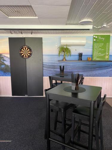 two tables and chairs in a room with a mural at Bedinge Golfklubb hotell in Beddinge Strand