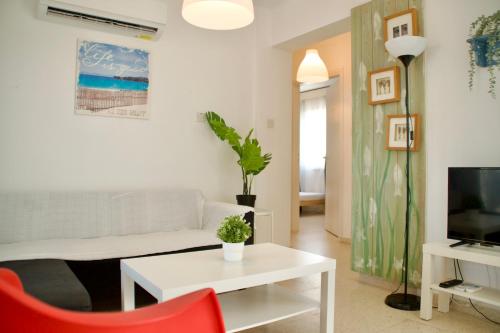 a living room with a white couch and a red chair at Yiallos Village Apt. A101 in Meneou
