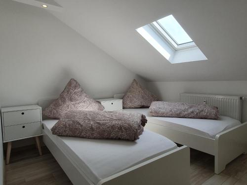 two beds in a attic room with a skylight at ruhige und moderne 2-Zi. Wohnung in Külsheim