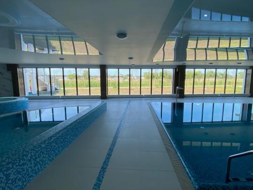 an empty swimming pool in a building with windows at Silver SPA - 22 in Dziwnów