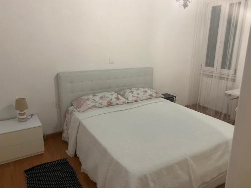 a white bedroom with a white bed and a window at Sunny house in SantʼAmbrogio di Valpolicella