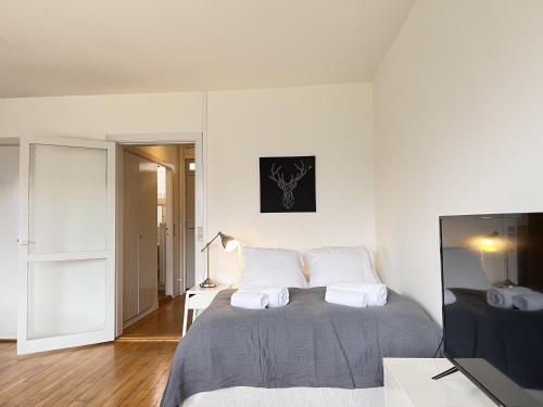 a white bedroom with a bed and a television at Studio Apartment In Herlev, Herlevgrdsvej 2, 4 in Herlev