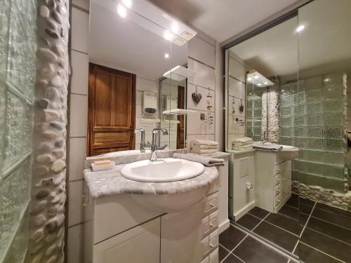 een witte badkamer met een wastafel en een douche bij Bel appartement rénové, avec terrasse et piscine in La Croix-Valmer