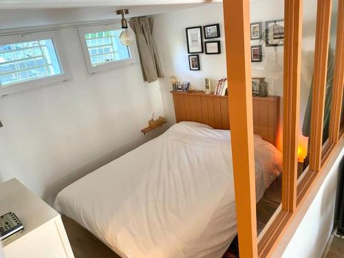 une petite chambre avec un lit et deux fenêtres dans l'établissement La Suite de la Maison Jaune, à Montpellier