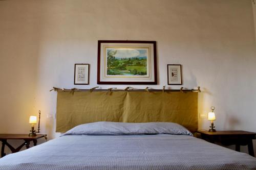 un letto in una camera da letto con due tavoli e due lampade di Il Borgo di Berentano a San Casciano in Val di Pesa