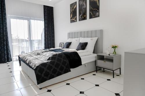 a white bedroom with a bed and a tiled floor at Silver SPA - 22 in Dziwnów