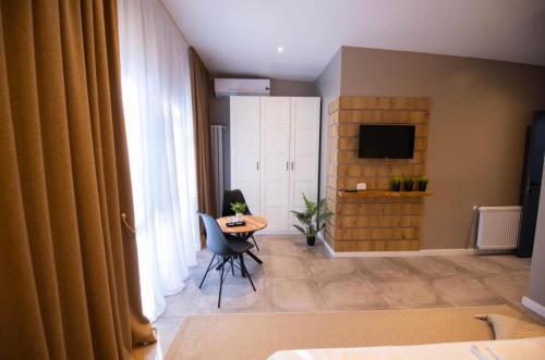 sala de estar con mesa y TV en Casa Doner Rooms en Craiova