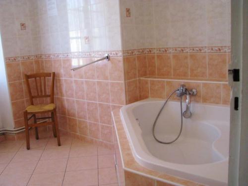 La salle de bains est pourvue d'une baignoire et d'une chaise. dans l'établissement Melabelle, à Malandry