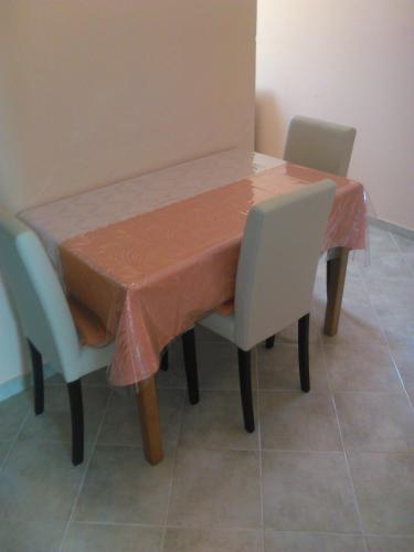 a table with two chairs and a table cloth on it at Apartments Zora in Vis