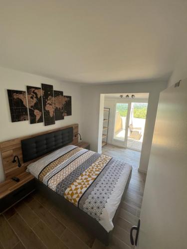 Schlafzimmer mit einem Bett und einer Tür zu einer Terrasse in der Unterkunft Mazet Bellevue in Cogolin