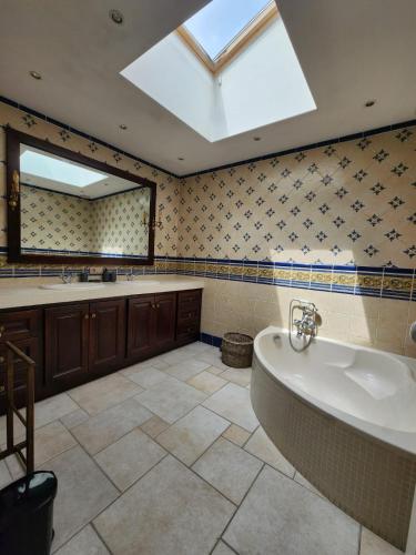 d'une grande salle de bains avec une grande baignoire et une lucarne. dans l'établissement La Maison du Bonheur, à Pau