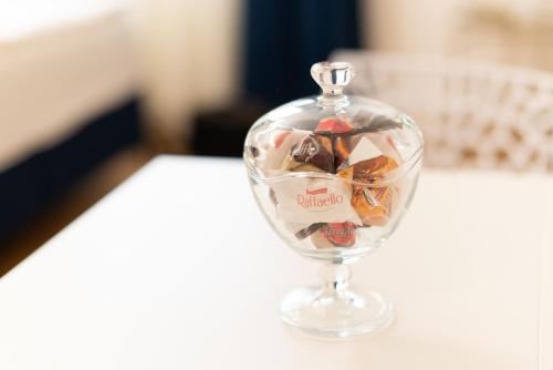 a glass jar filled with different types of candy at Studio 106 Apartment in Palić