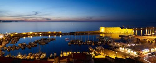 a marina at night with boats in the water at The Fifty Condo in Heraklio Town