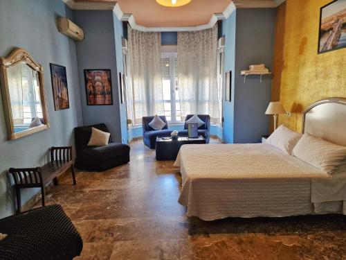 1 dormitorio con 1 cama y sala de estar en Apartamento El Duque - Plaza de las Tendillas en Córdoba
