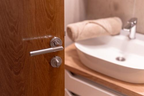 a bathroom door with a sink in front of it at Studio 106 Apartment in Palić