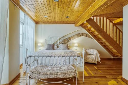 a bedroom with a metal bed with a wooden ceiling at InLoveApartments - Amazing Duplex at Alfama in Lisbon