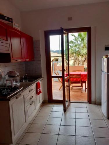 a kitchen with a door open to a patio at I Coralli in Villasimius