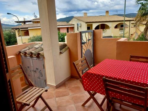a table and chairs on a balcony with a view of a house at I Coralli in Villasimius