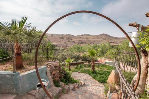 an archway in a garden with a view of the desert at La Fattoria Ecolodge in Lalla Takerkoust