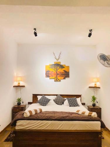 a bedroom with a large bed with two lamps at The kingdom of ella in Ella