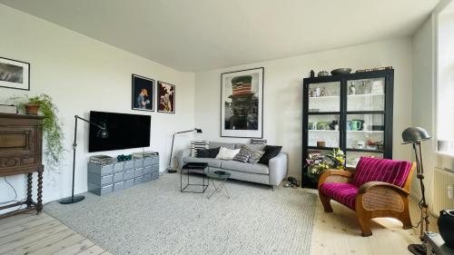 uma sala de estar com um sofá e uma televisão em ApartmentInCopenhagen Apartment 1548 em Copenhague