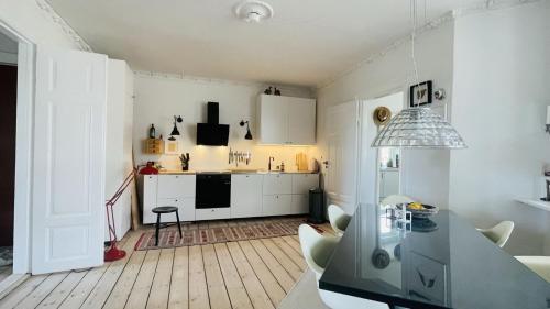 cocina con armarios blancos y mesa de comedor en ApartmentInCopenhagen Apartment 1548, en Copenhague