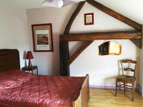 a bedroom with a bed and two chairs in a room at Les mallinettes in La Neuville-aux-Joûtes
