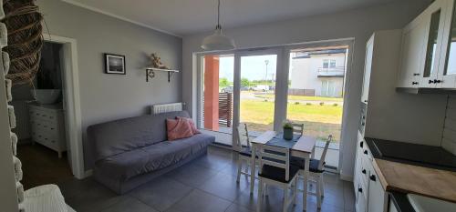een woonkamer met een bank en een tafel bij Apartamenty "u Jasia" I in Darlowko