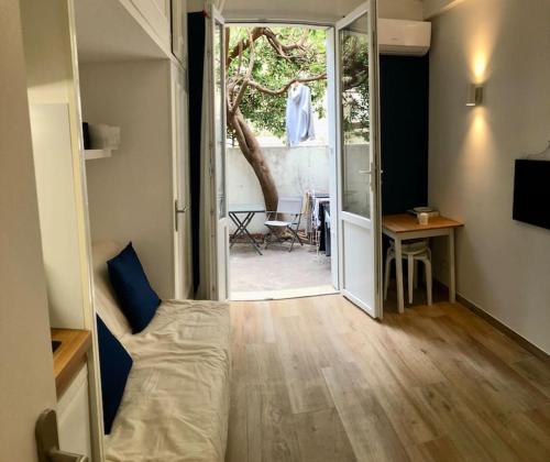 Cette chambre comprend un lit, une table et une porte. dans l'établissement Studio bord de mer, Croisette, Cannes, à Cannes