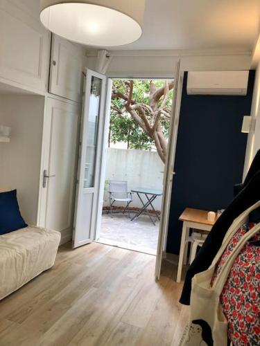 une chambre avec un lit et une porte coulissante avec une table dans l'établissement Studio bord de mer, Croisette, Cannes, à Cannes
