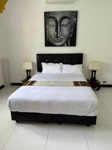 a large bed in a room with two lamps at Villa Happy home in Rawai Beach