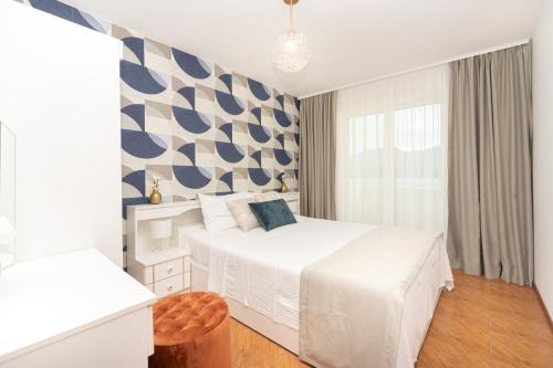 een slaapkamer met een wit bed en een groot raam bij Apartments Adeona in Tivat