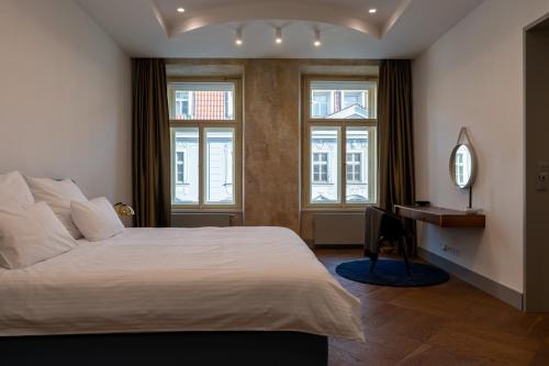 um quarto com uma cama, uma secretária e janelas em Luxury Old Town Apt, parking em Praga