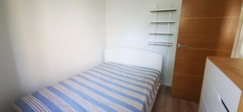 a small room with a blue and white bed at 29 Smithwood close in London