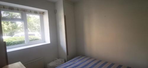 a bedroom with a bed and a window at 29 Smithwood close in London