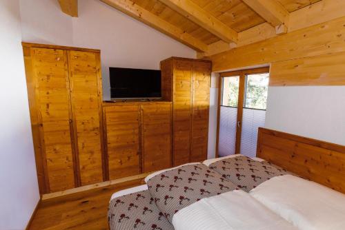 a bedroom with a bed and a flat screen tv at Chalet Alpenloft 1 in Mittenwald