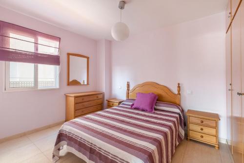 a bedroom with a bed with a purple pillow on it at Apartamento Clayma in Puerto de Mazarrón