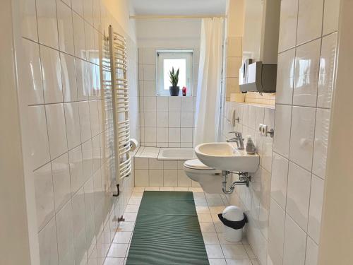 a bathroom with a sink and a toilet with a green rug at 3 Betten Unterkunft Vahrenwald-List in Hannover