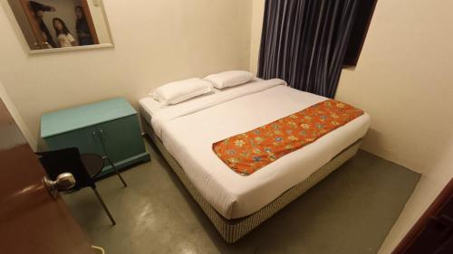a bed in a small room with a bed sidx sidx sidx at Wao Sayang Sayang Guest House in Melaka