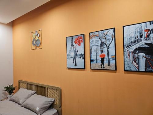 a wall with four pictures on it with a bed at Mây Homestay in Hanoi