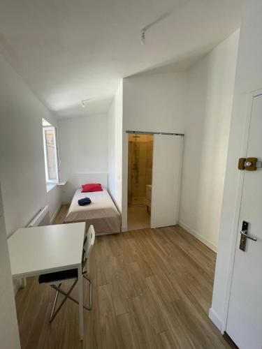 une chambre avec un lit, un bureau et une table dans l'établissement joli appartement plein sud 15mn des plages et wifi gratuit, à Marseille