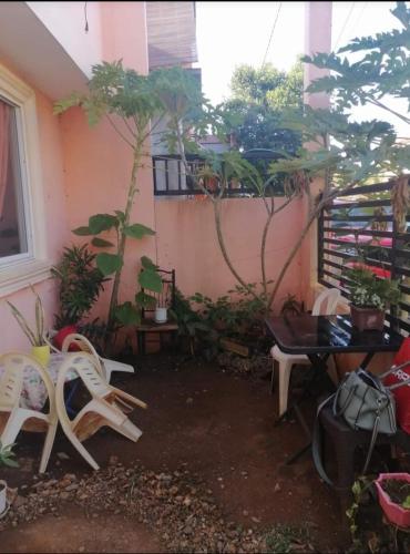 un patio con sillas y plantas en un edificio en Island Princess Guesthouse, en Puerto Princesa City