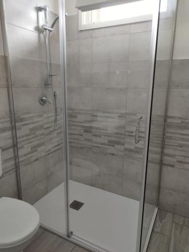 a bathroom with a glass shower with a toilet at b&b Casa Balai 72 a 100 mt dal mare in Porto Torres