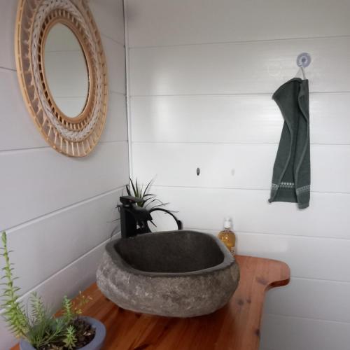 a bathroom with a stone sink on a wooden table at La petite maison dans la prairie 