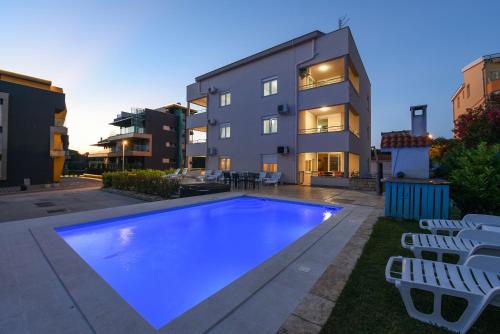 a swimming pool in front of a building at Sunset Beach Suites in Kožino