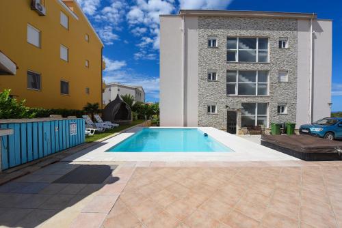 a swimming pool in front of a building at Sunset Beach Suites in Kožino
